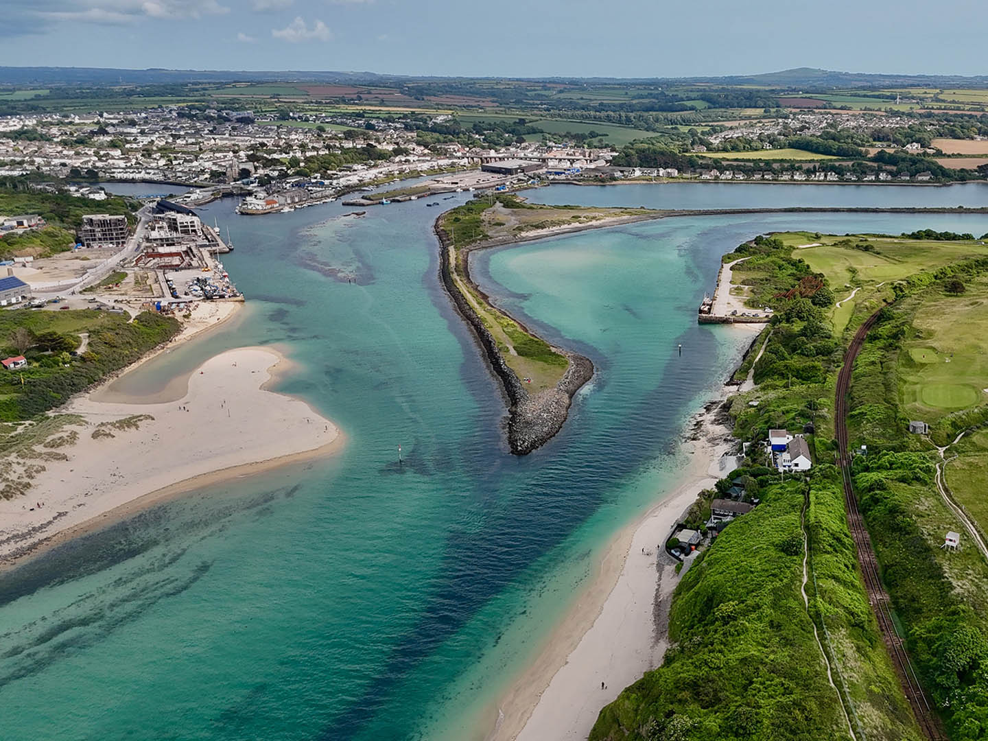 Aerial view of Hayle Estuary, showcasing the beach and town nestled along the coastline, this estuary played a key part in the history of Hayle.