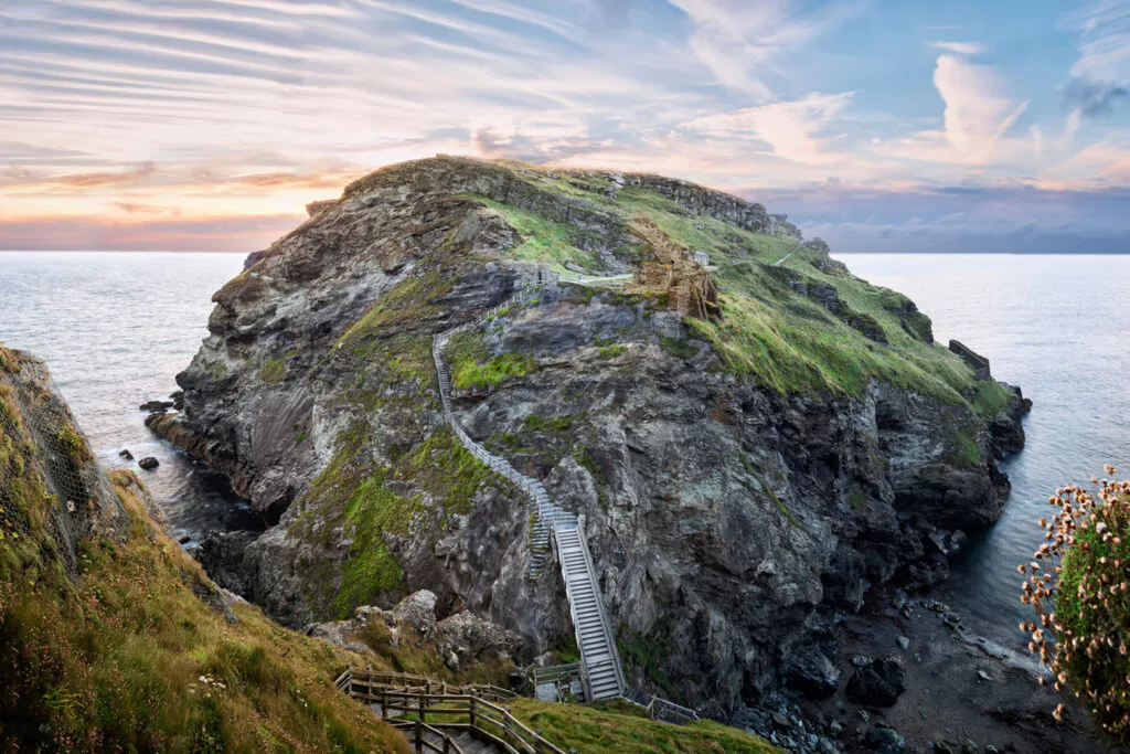 Peninsula of Tintagel Island and legendary castle ruins at sunset