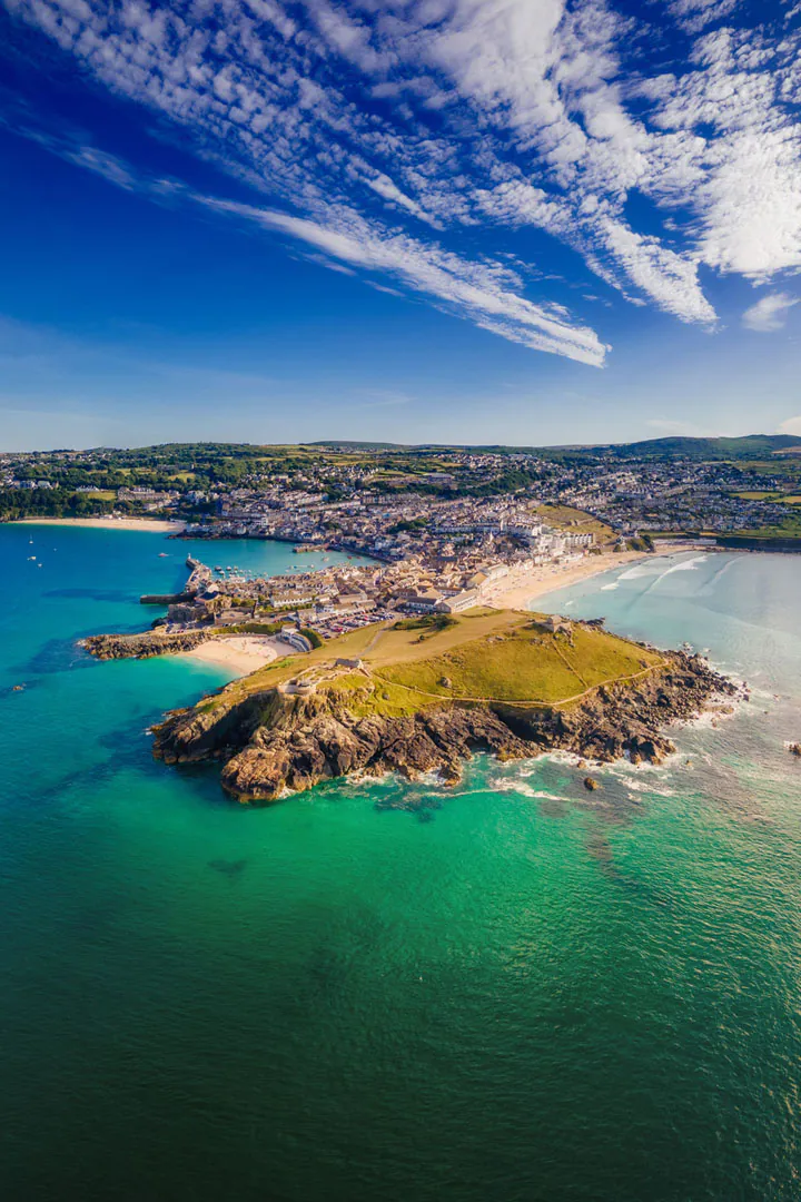 Aerial view of St Ives, showcasing a sandy beach and the charming town nestled along Cornwall's coastline.
