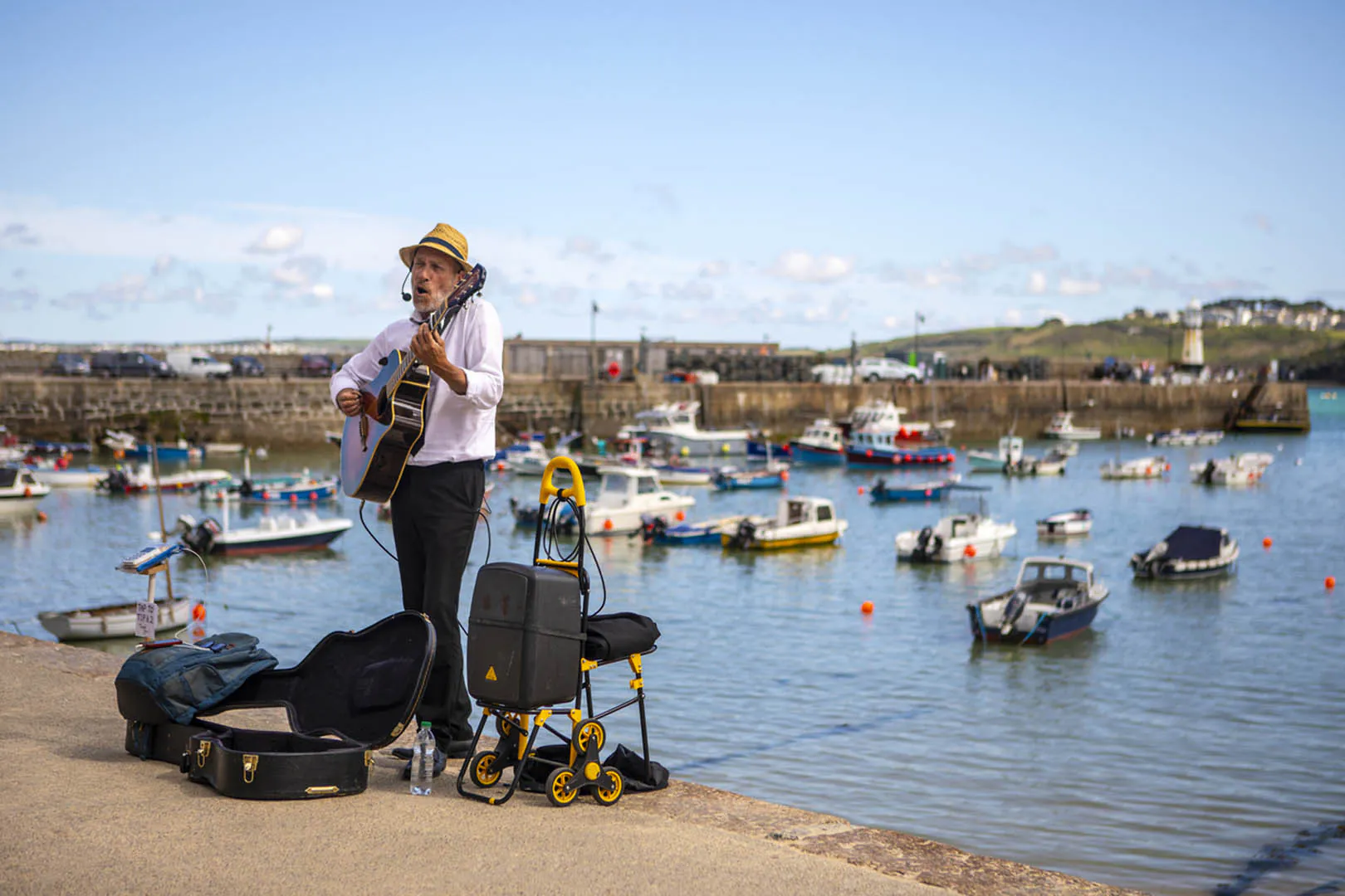 A man strumming his guitar in St Ives during the St Ives September Festival, creating a vibrant atmosphere for the town.