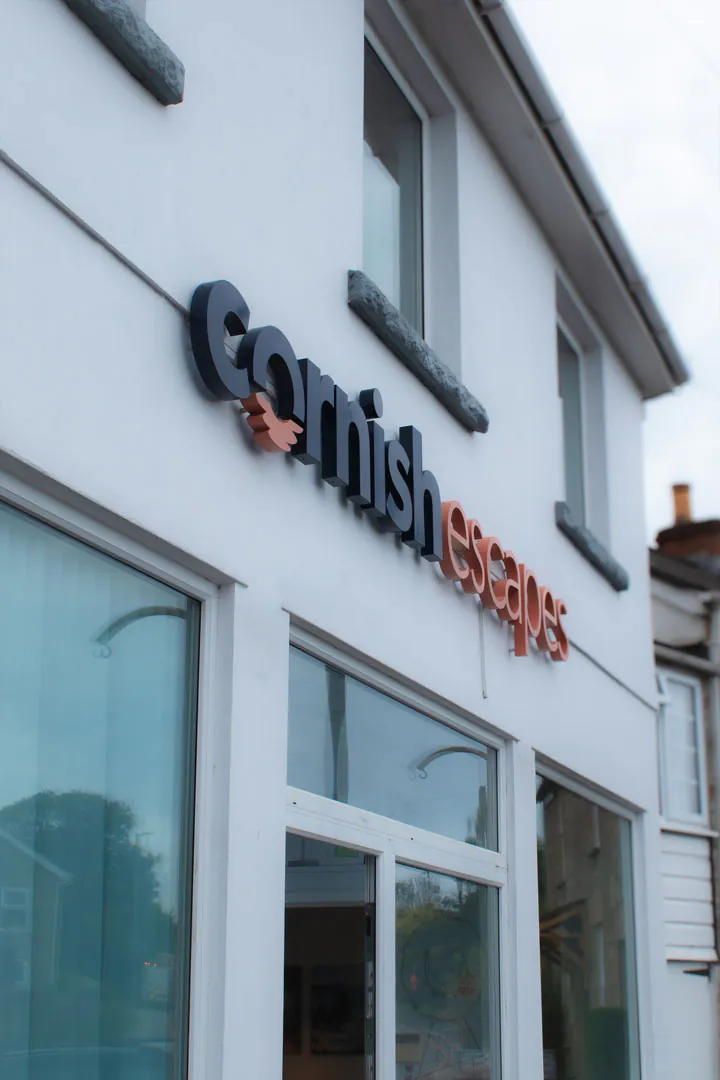 Exterior view of the new Cornish Escapes office in Carbis Bay, featuring a prominent sign displaying the company name.