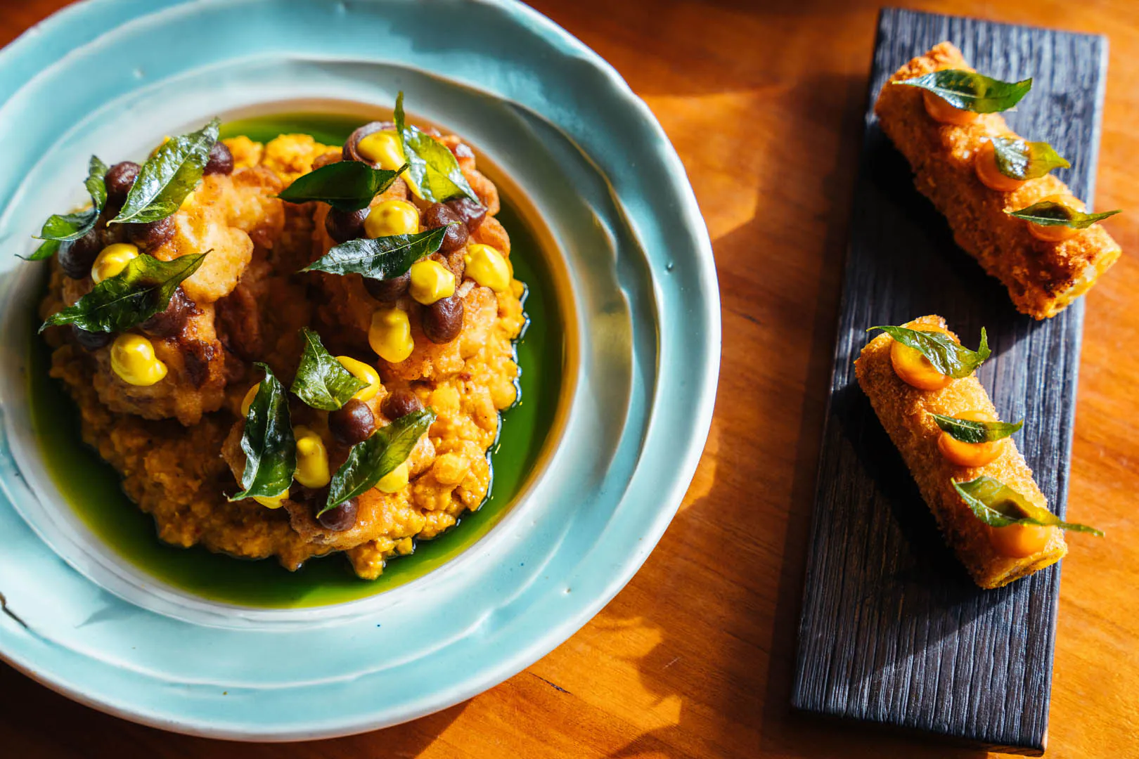 A plate of delicious food accompanied by a side dish, showcasing a meal from Kota Restaurant in Porthleven, Cornwall, a great place to eat out in Cornwall.