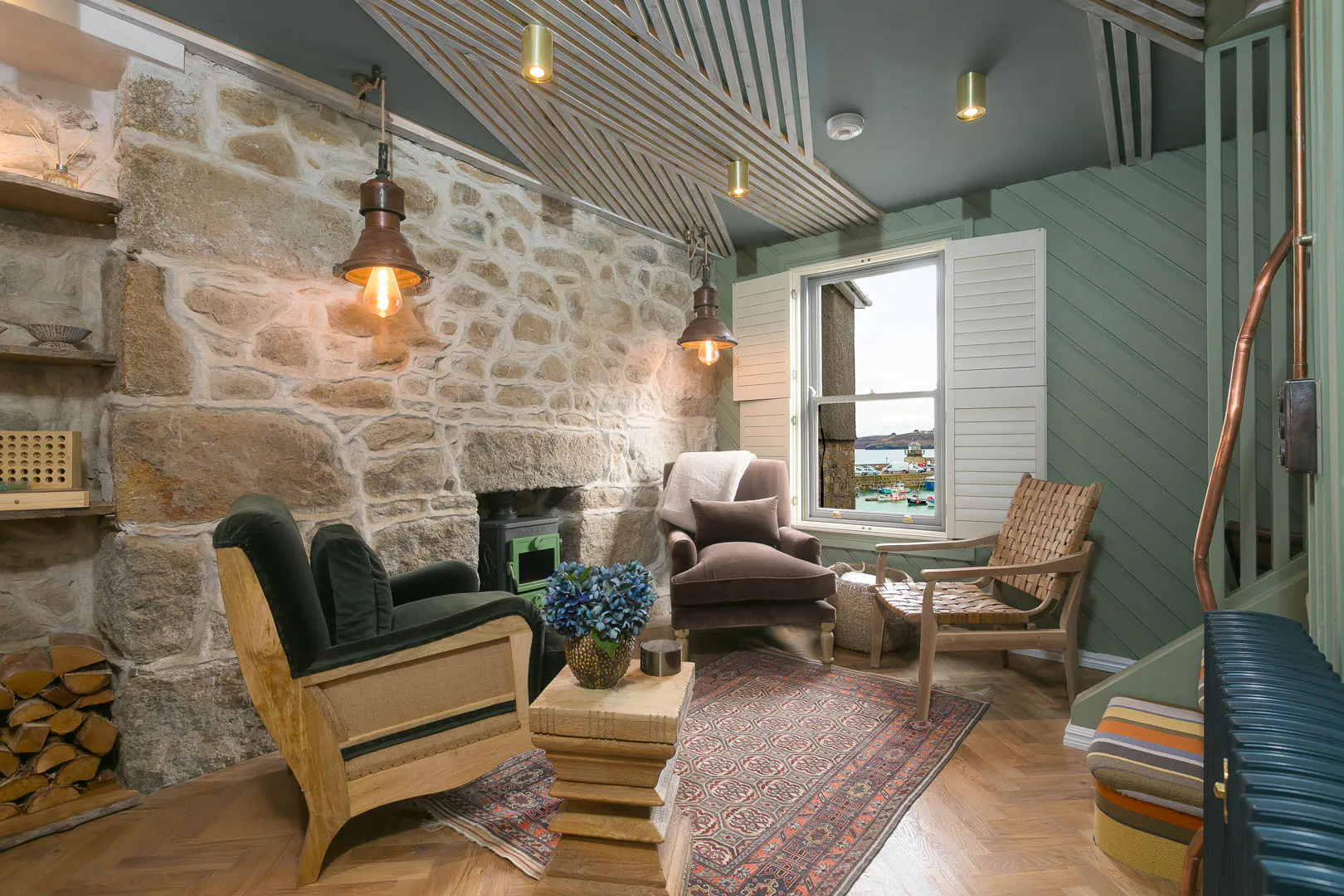 Cosy living room featuring a stone wall and fireplace, showcasing the charm of She Sells Sanctuary, a holiday cottage in St Ives.